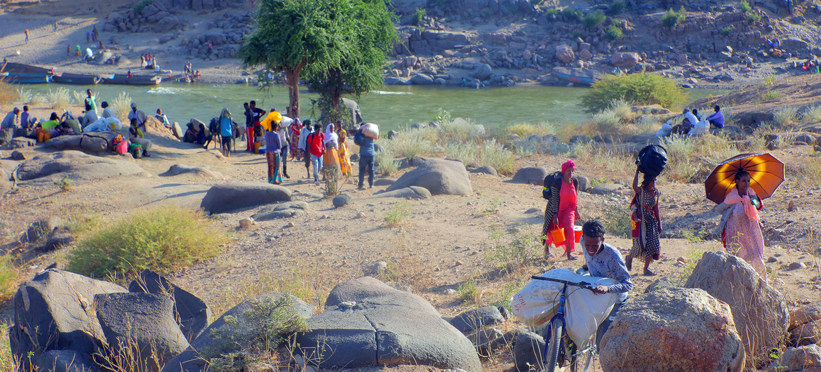 Ethiopian refugees, fleeing clashes in the country's northern Tigray region, cross the border into Hamdayet, Sudan, over the Tekeze river.